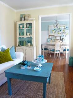 For our coffee table. Ill add color with furniture rather than walls. Repainted table used as coffee table. The color chosen is magnificent. It matches the chair seats of the chairs in the next room. And look at the lovely corner cabinet, with the interior painted blue. Great use of flea market finds. Biddy Craft