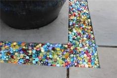 Colored glass Instead of gravel in the garden or patio...you can get these at the dollar store.